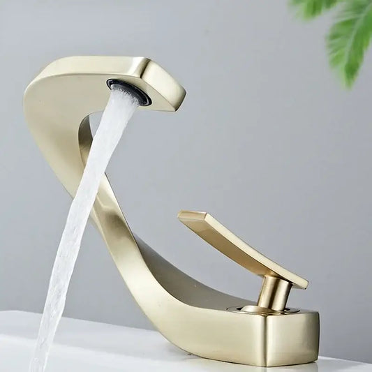 Modern gold-toned waterfall brass basin faucet with sleek curved design and single lever handle for bathroom decorbites brass basin