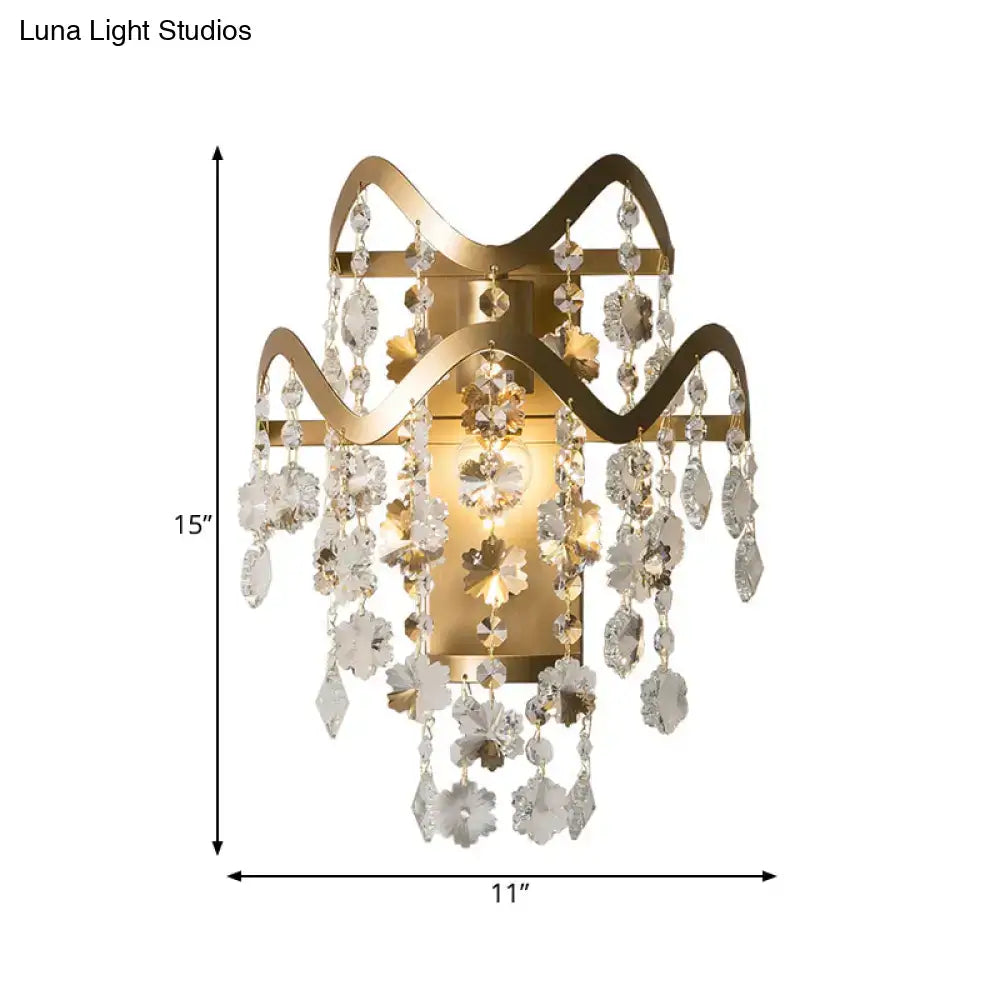 Modern gold wave sconce with shell accent featuring cascading crystal flowers and teardrop direct wired electric design