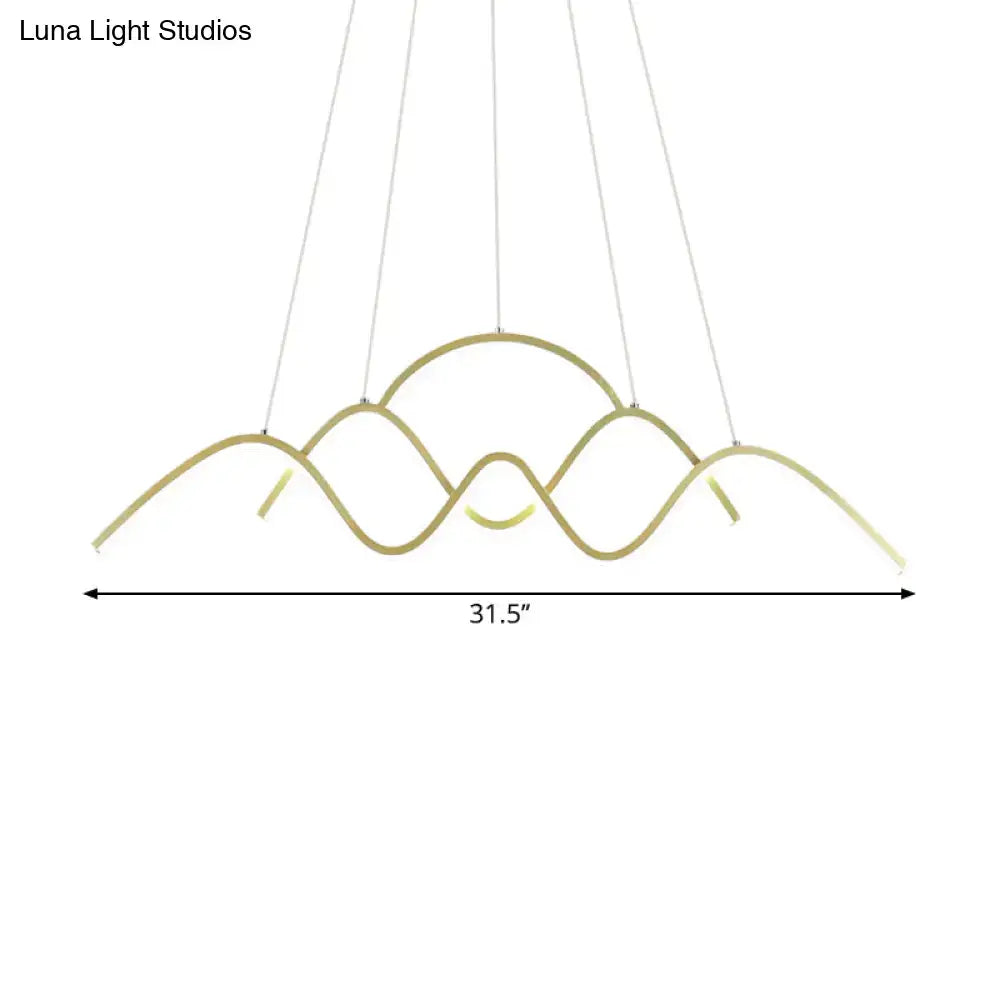 A modern gold-toned led pendant light with wavy design and multiple cables featuring warm white light decorbites