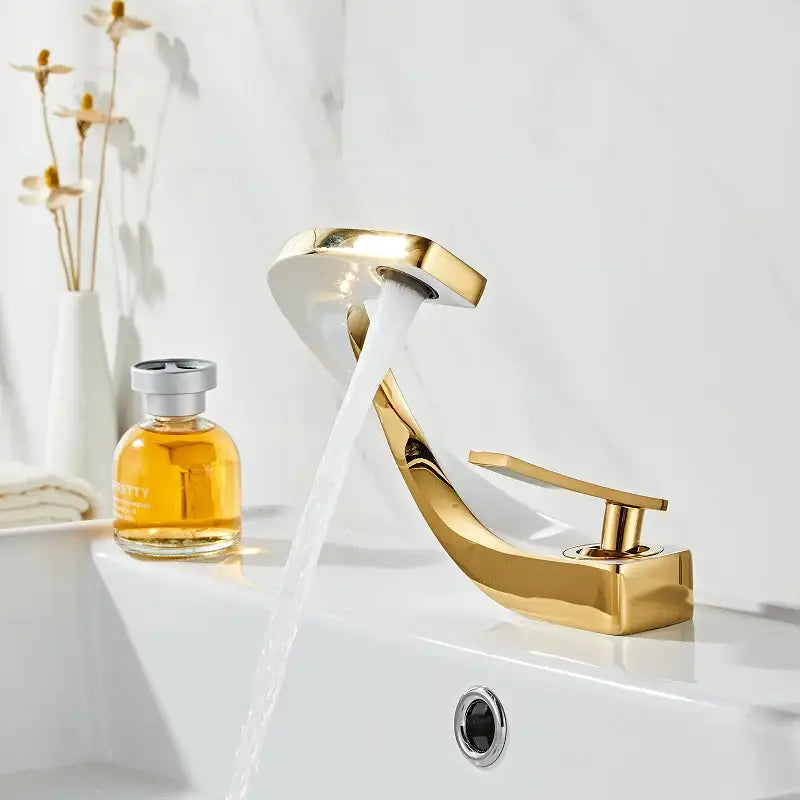 Modern gold and white bathroom basin faucet with gold-colored waterfall spout and polished metallic finish for decorbites gold white decor