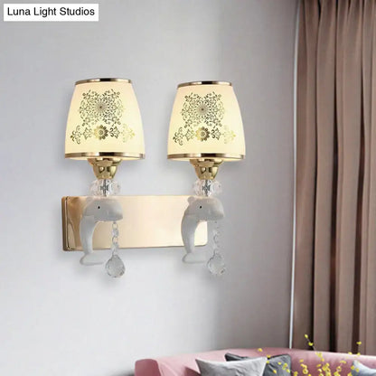 Modern gold and white dolphin wall sconce with opal glass shade, gold floral lampshades, ceramic elephants, and crystals