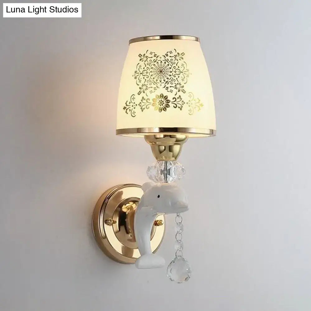 Modern gold and white dolphin wall sconce with opal glass shade featuring gold metal base and crystal accents