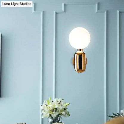Modern gold wall sconce with white glass globe and sleek cylindrical base compatible with e26 e27 bulbs for bedroom use