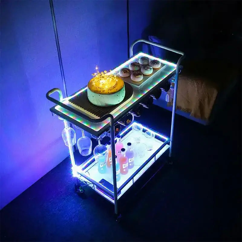 A modern gold and white marble bar cart with glass shelves and colorful led lights functions as a stylish drinks trolley and wine rack
