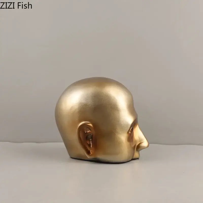 Modern golden abstract resin sculpture of a bald human head in profile with smooth contours for office decorbites decor