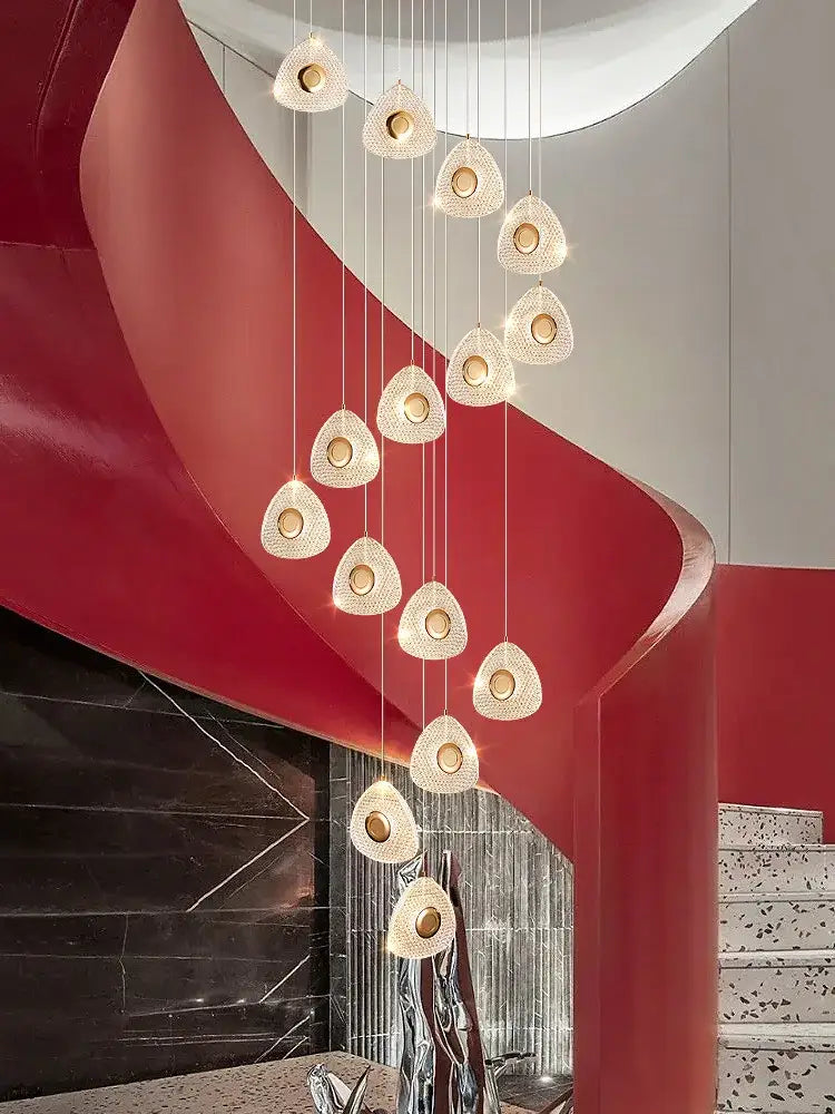 A modern golden acrylic led chandelier with teardrop crystal fixtures suspended from thin cords for living room decorbites
