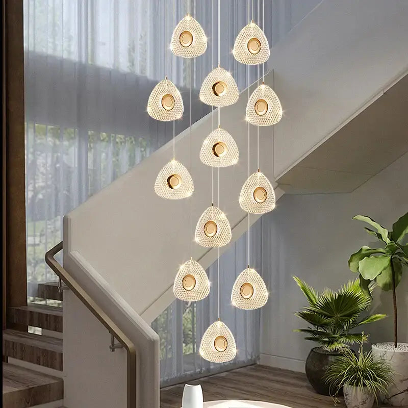 A modern golden acrylic led chandelier with clear crystal teardrop lights and gold-toned accents for living room decorbites