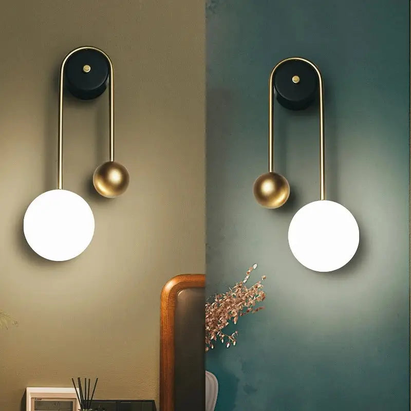 Modern wall lamp with sleek brass frame, black base, and glowing white spherical shade with gold accent by decorbites golden ball led