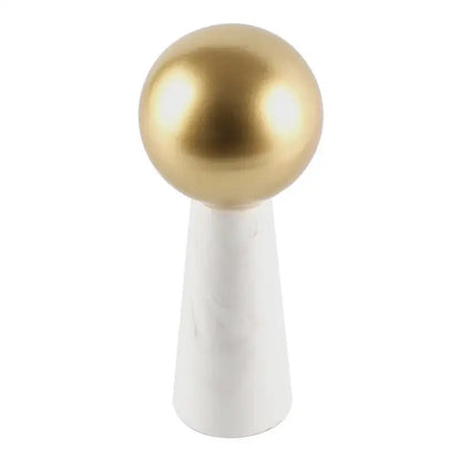 A modern table lamp with a golden ball shade and white marble cone base as a living room spherical ornament