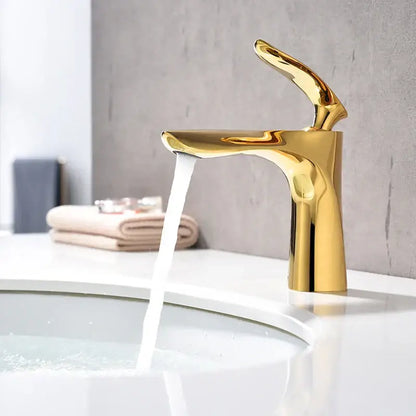 A sleek modern decorbites golden bathroom faucet with a polished metallic finish and curved single handle basin tapware