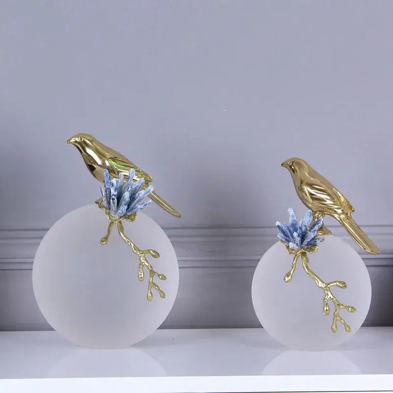 Modern golden bird brass sculpture with blue crystal branches atop frosted white bases for living room decorbites decor