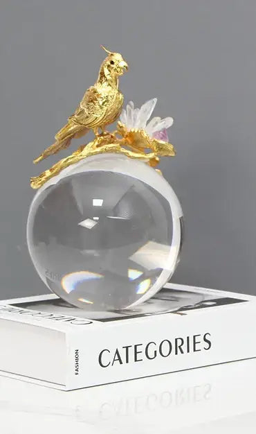 Modern golden bird brass sculpture with blue crystal globe and floral accents for living room decorbites golden bird decor