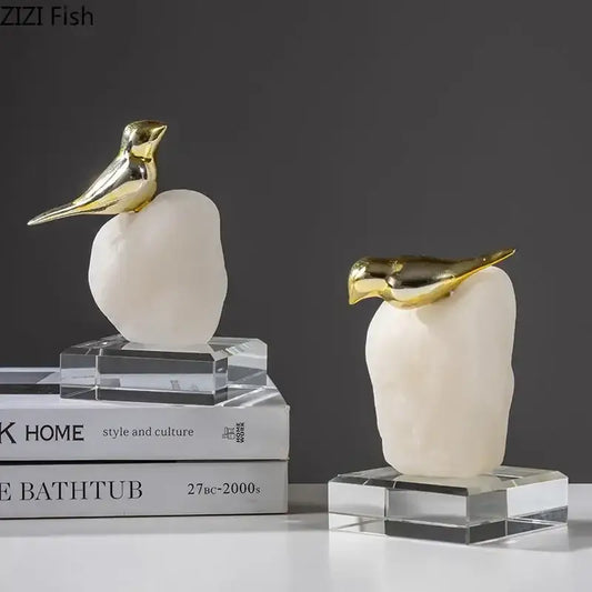 Modern golden bird statue with a smooth off-white stone base perfect as a living room ornament bird statue