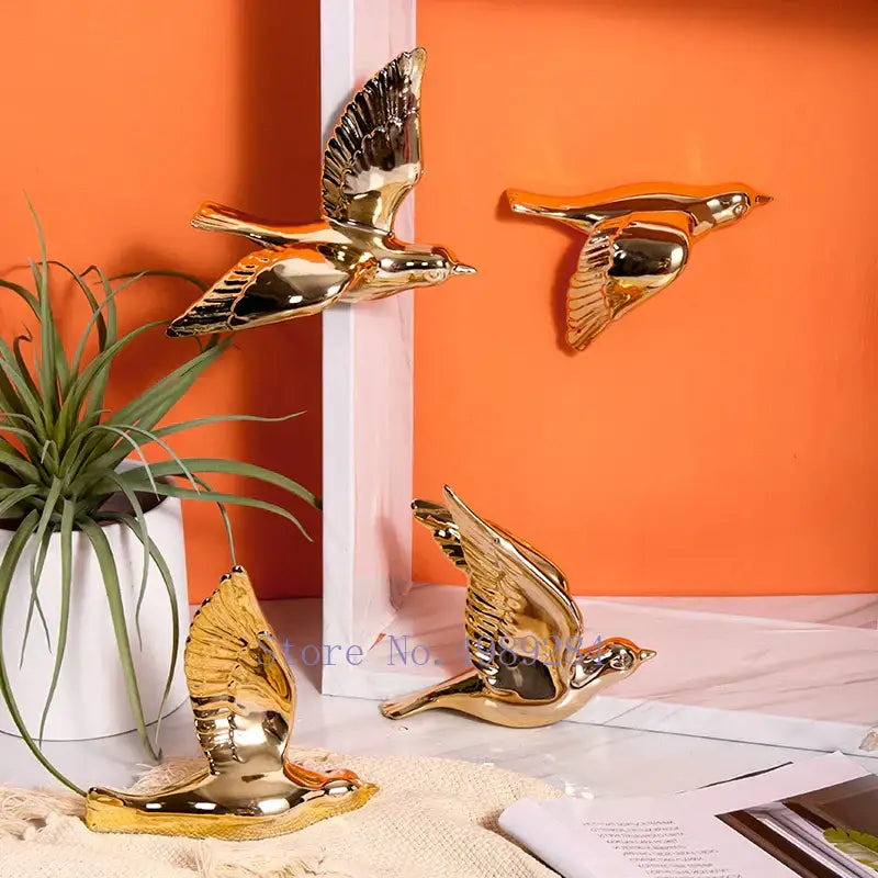 Modern golden bird wall hanging with shiny gold reflective surfaces and detailed feathered wings for living room decor