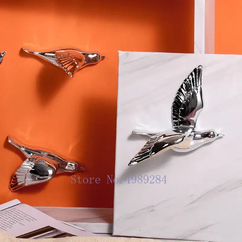 Modern golden bird wall hanging with shiny silver reflective surface and detailed wings for living room decor