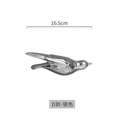Silver metallic bird figurine with sleek reflective surface and detailed wings for modern golden bird wall hanging decor