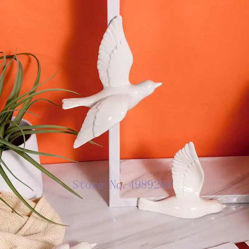 White ceramic bird figurine with glossy finish in mid-flight pose for modern golden bird wall hanging decor