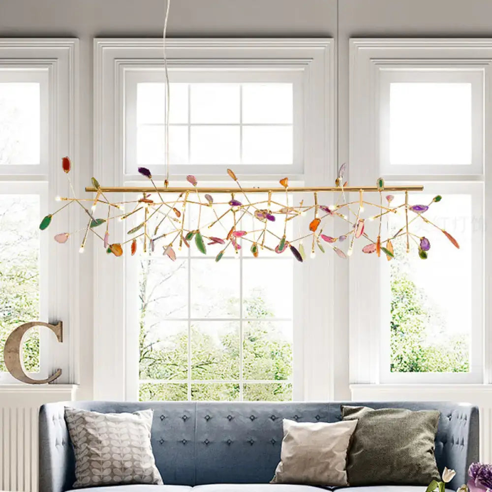 DecorBites modern gold metal pendant light fixture with agate accent and adjustable cord length above blue sofa