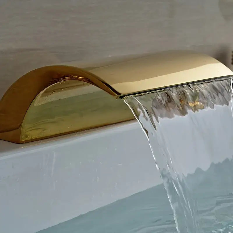 Modern golden brass bathtub faucet with sleek curved waterfall spout and polished decorbites golden brass finish