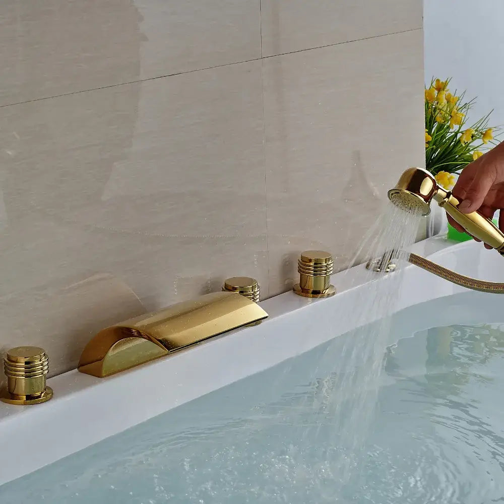 Modern golden brass bathtub faucet with sleek cylindrical handles and handheld shower by decorbites golden brass