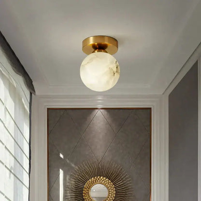 Modern golden brass ceiling lamp with gold finish and white marble-like glass globe for bedroom decorbites golden brass