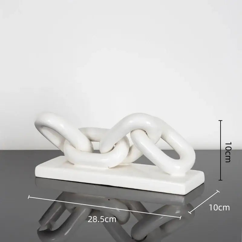 White ceramic chain sculpture on a rectangular base featuring a golden chain home decoration figurine for living room decor