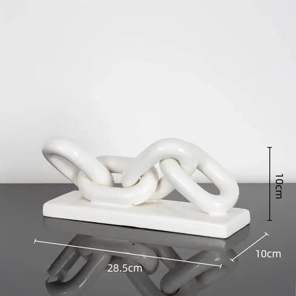 White ceramic chain sculpture on a rectangular base featuring a golden chain home decoration figurine for living room decor