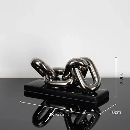 Modern golden chain home decoration figurine made of shiny metallic material on a black glossy base for living room display