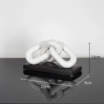 White ceramic chain sculpture on black base as modern home decoration figurine contrasting golden chain style