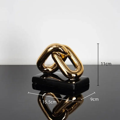 Modern golden chain home decoration figurine in glossy gold finish resting on sleek black base for living room decor