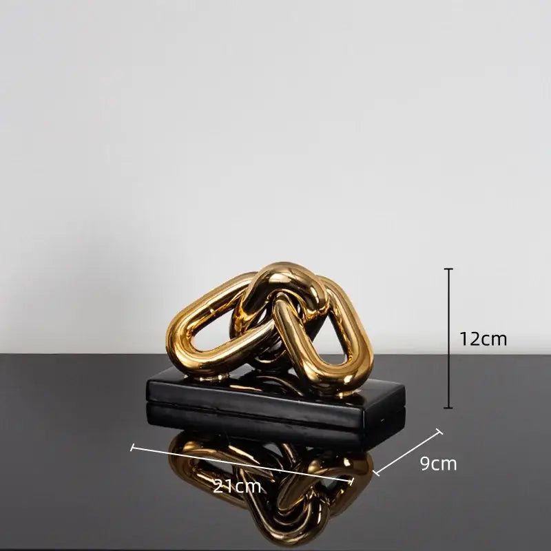 Modern golden chain home decoration figurine in metallic gold resting on black rectangular base for living room decor