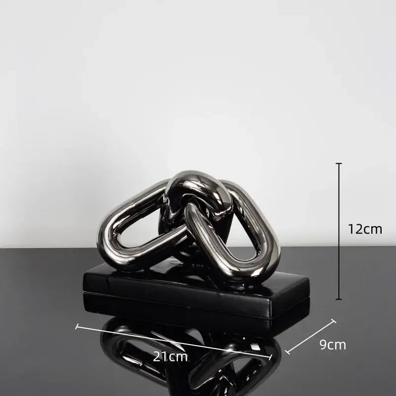 Shiny black metallic chain sculpture on matching base as a modern home decoration figurine for living room decor