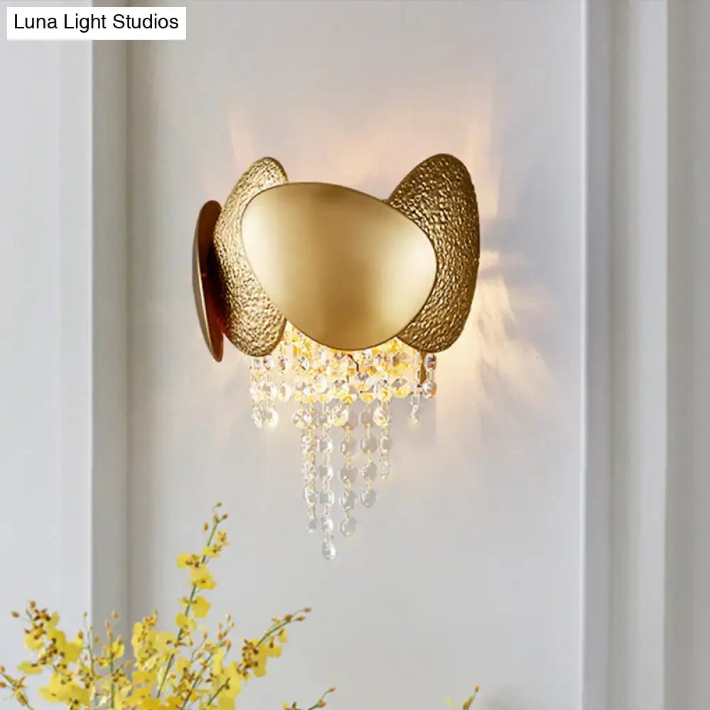 Modern golden egg wall mount light featuring a gold-toned sculptural design with dangling crystal beads for bedroom use
