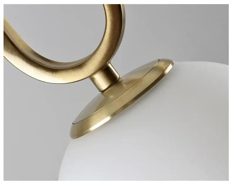 Modern golden glass ball pendant light with a brass-finished metal frame and smooth white globe for kitchen decorbites golden glass