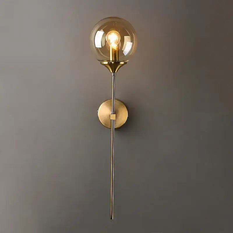Modern brass-finished wall lamp with a golden glass ball amber globe and exposed filament bulb for bedroom decorbites golden glass