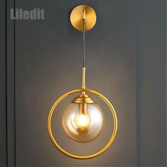 Modern golden glass ball wall sconce with a gold-toned circular frame and clear globe for living room decorbites golden glass