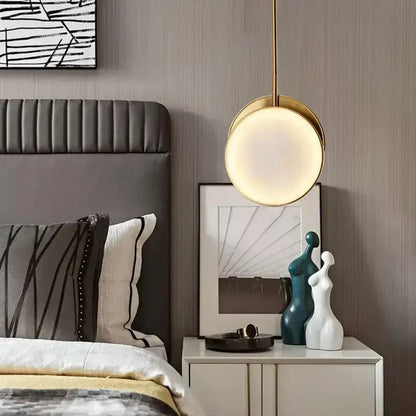Modern golden marble led pendant light with gold-toned circular design hanging above bedside table decorbites golden marble