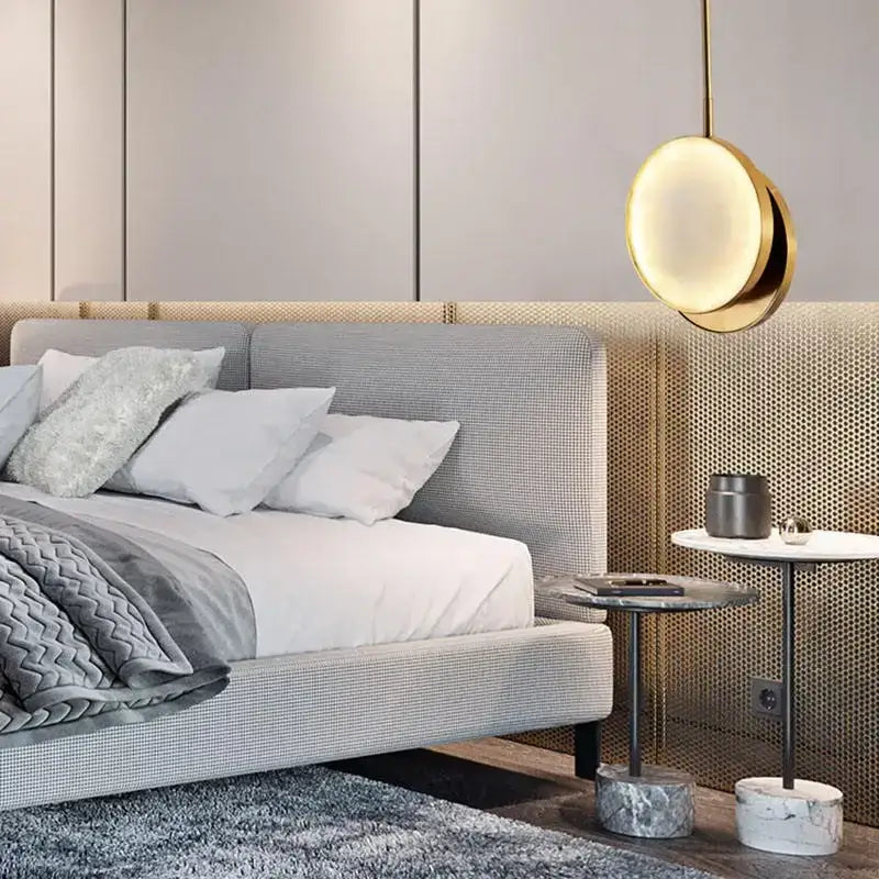 Modern golden marble led pendant light with a gold-toned circular design hanging above the bedroom bed decorbites golden marble