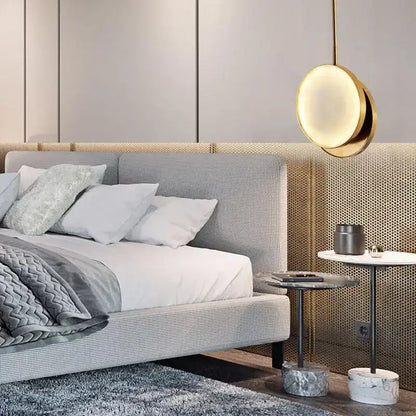 Modern golden marble led pendant light with a gold-toned circular design hanging above the bedroom bed decorbites golden marble