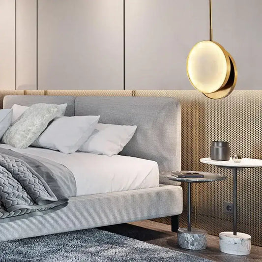 Modern golden marble led pendant light with a gold-toned circular design hanging above the bedroom bed decorbites golden marble