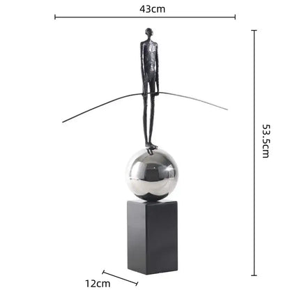 A sleek golden metal abstract figure sculpture on a reflective silver sphere base for modern living room decorbites decor