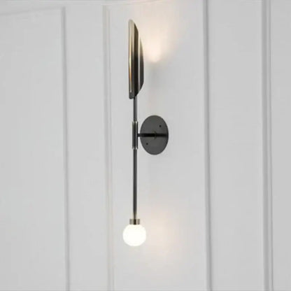 Modern golden metal glass wall lamp with sleek black metal sconce featuring an illuminated globe bulb decorbites golden metal wall lamp