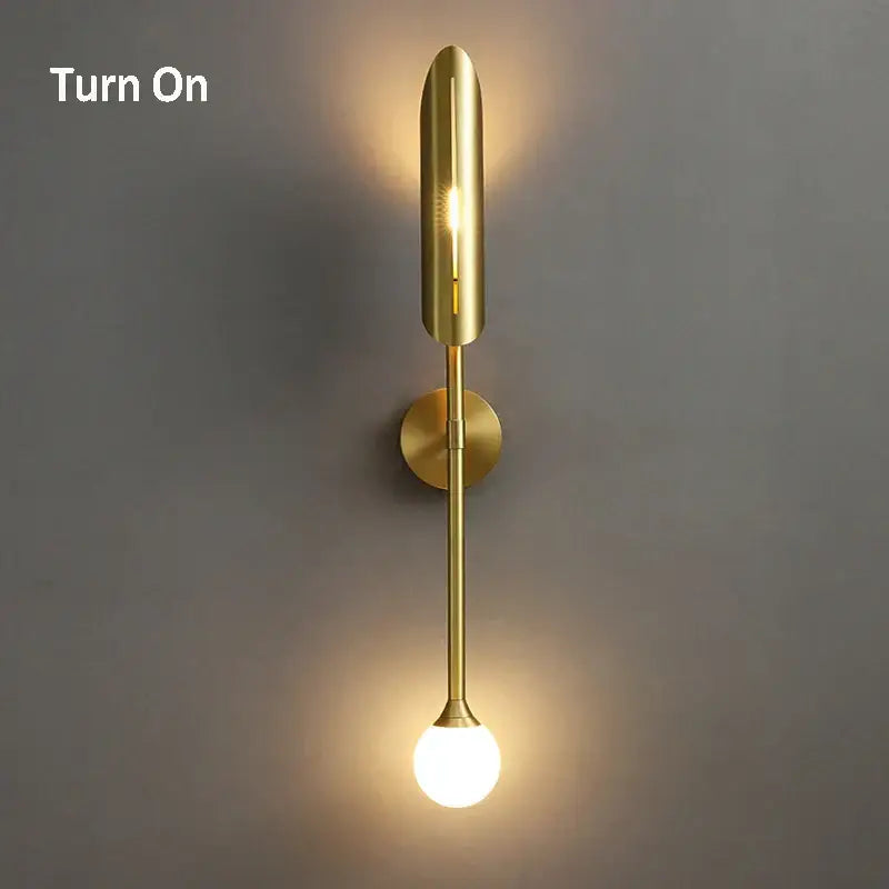 Modern golden metal glass wall lamp with sleek elongated design and spherical bulb base for bedroom decorbites golden metal sconce