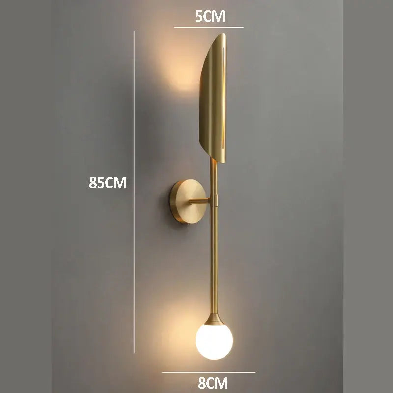 Modern golden metal glass wall lamp with sleek leaf-shaped fixture and spherical bulb for bedroom decorbites golden metal sconce