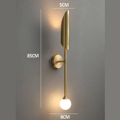 Modern golden metal glass wall lamp with sleek leaf-shaped fixture and spherical bulb for bedroom decorbites golden metal sconce