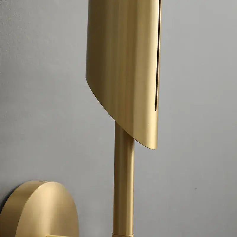 Modern golden metal glass wall lamp with a gold-toned curved shade and cylindrical stem by decorbites golden metal
