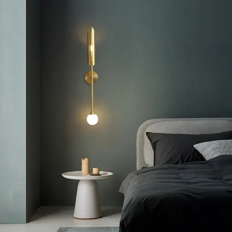 Modern golden metal glass wall lamp bedroom sconce with sleek elongated cylindrical body and round base decorbites golden metal