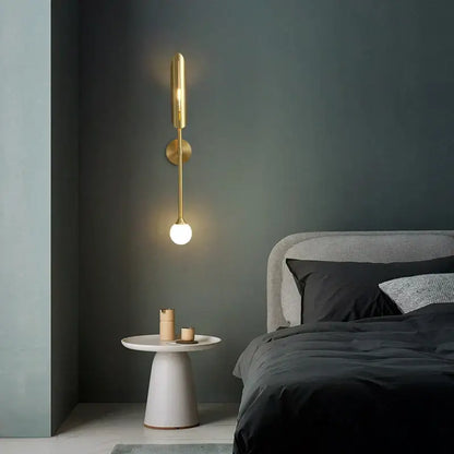 Modern golden metal glass wall lamp bedroom sconce with sleek elongated cylindrical body and round base decorbites golden metal