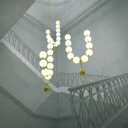 Modern golden necklace chandelier with glowing white spherical bulbs and gold-toned metallic accents for dining room luxury light