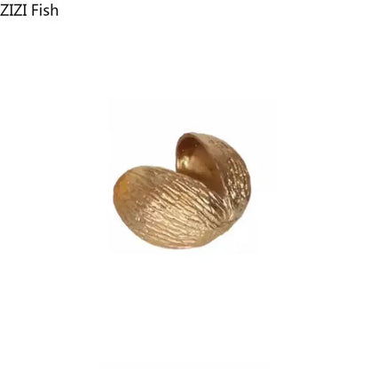 Modern golden nut shell ornaments desk decor featuring a textured glossy golden nut shell by decorbites
